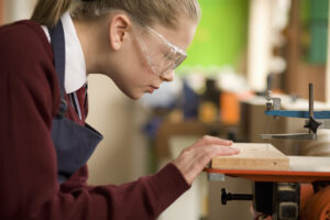 Student using jigsaw in wood shop class